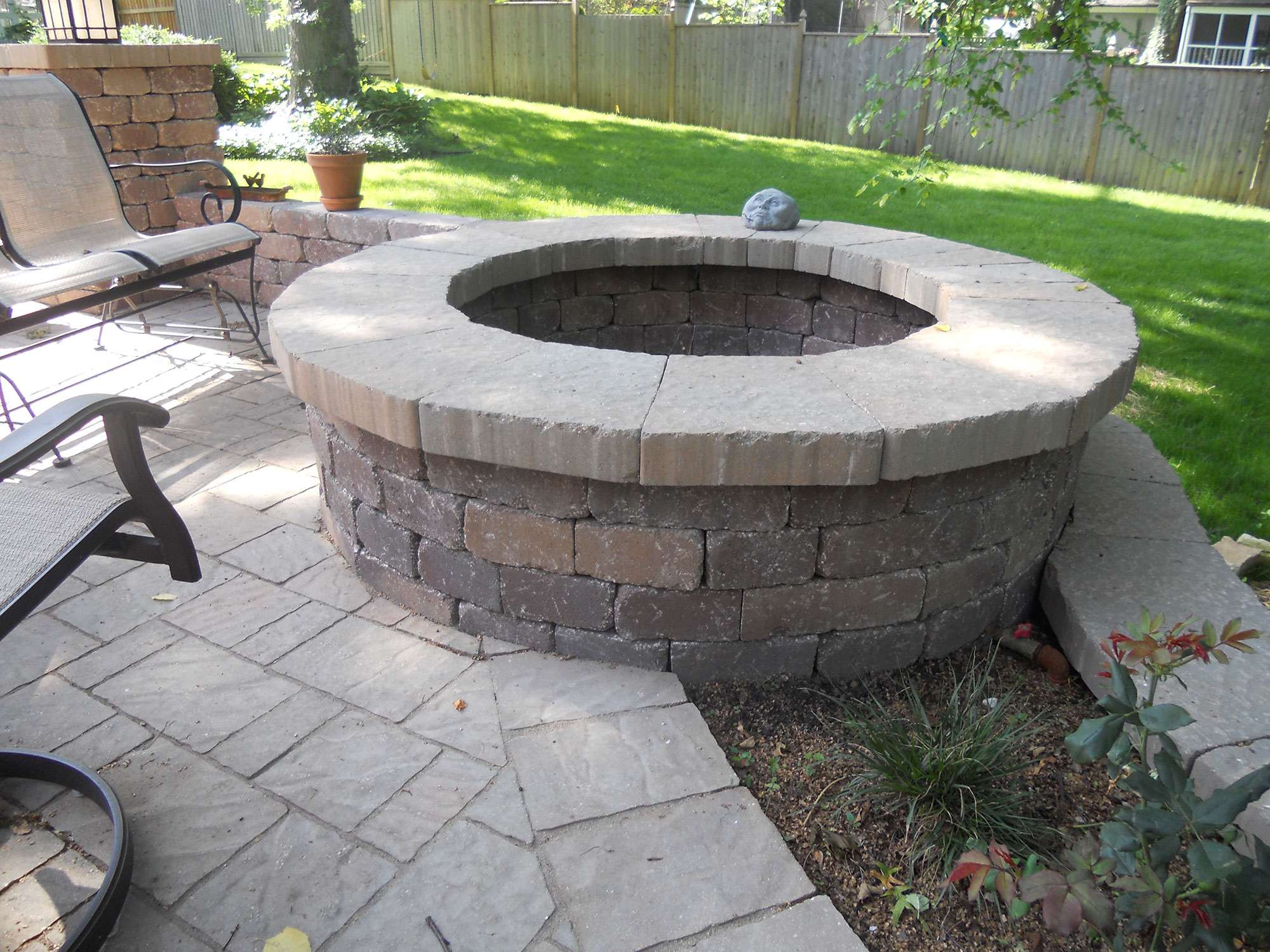 Stone outdoor fireplace and seating area built by Outlook Hardscape